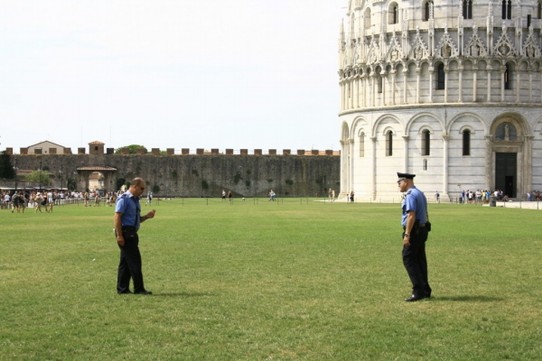 Italy - Pisa - Carabinieri verjagen mit Pfeifen auf dem Rasen sitzende Touristen.