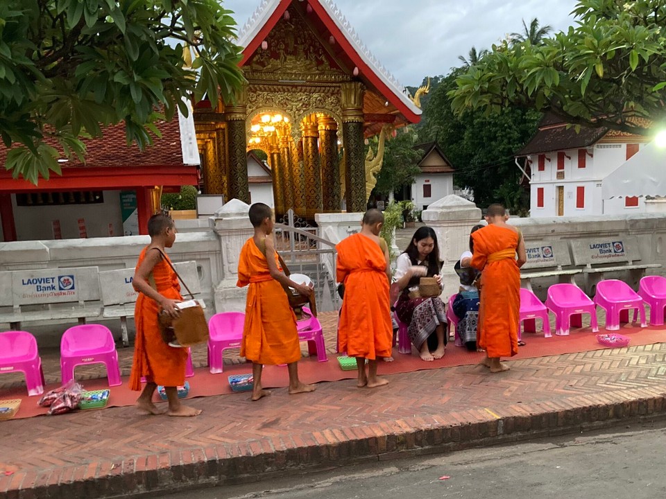 Laos - Vang Vieng - 5:30 Sonnenaufgang und Alms giving für die Mönche. Die Menschen geben Sticky Rice und Kekse in die Töpfe der Mönche