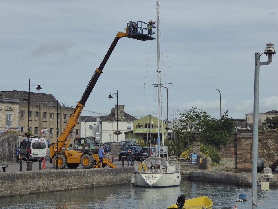 Ireland - Dungarvan - A yacht tied up against the harbour wall so a cherry picker could be used rather than someone climbing the mast.