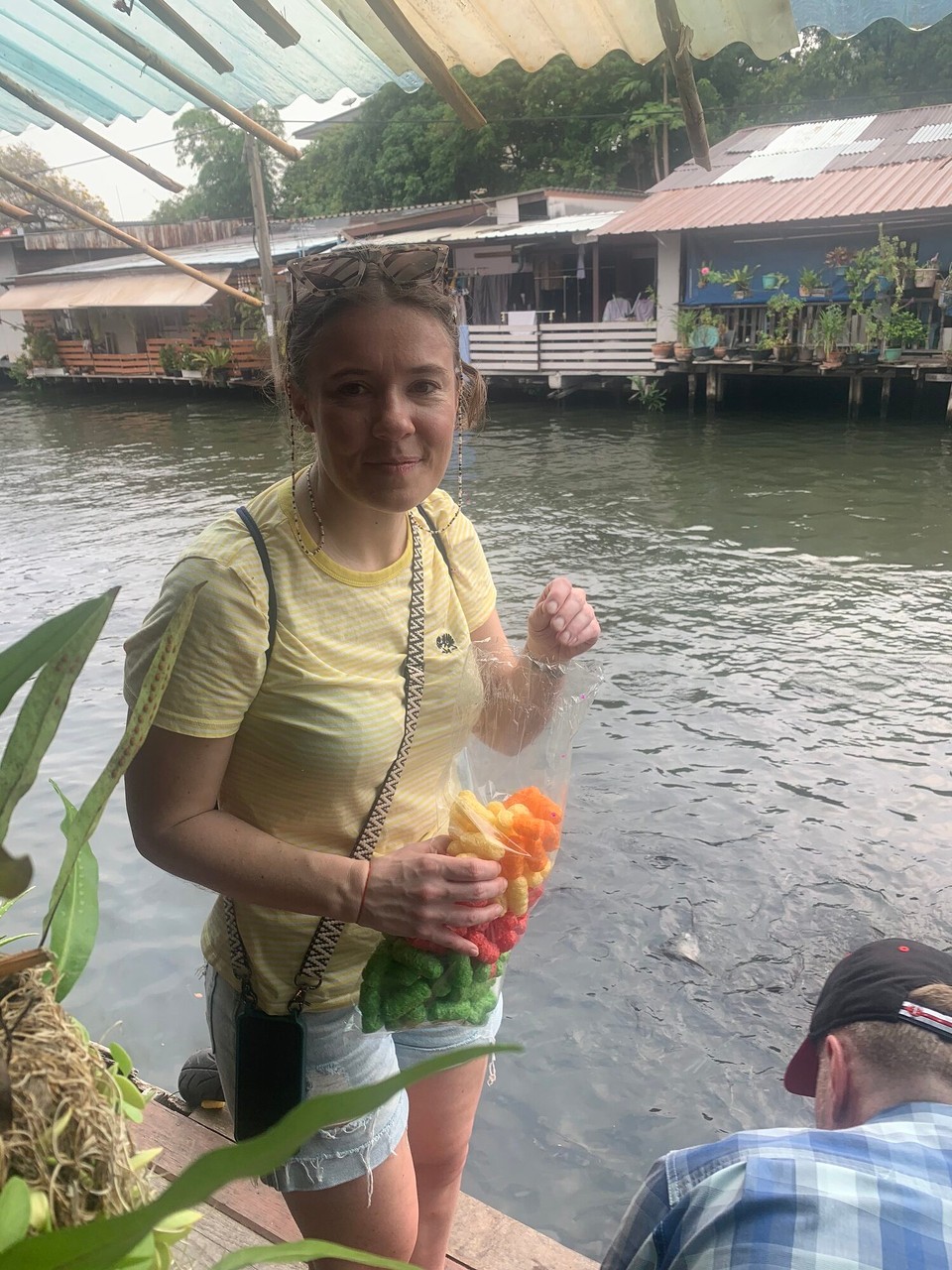 Thailand - Bangkok - Noch könnt ihr nicht sehen was gleich passieren wird: Milena wird bunte Mais-Puffer in den Fluss werfen und damit etliche Welse locken die sich um das Essen prügeln werden. Noch ist es ruhig…