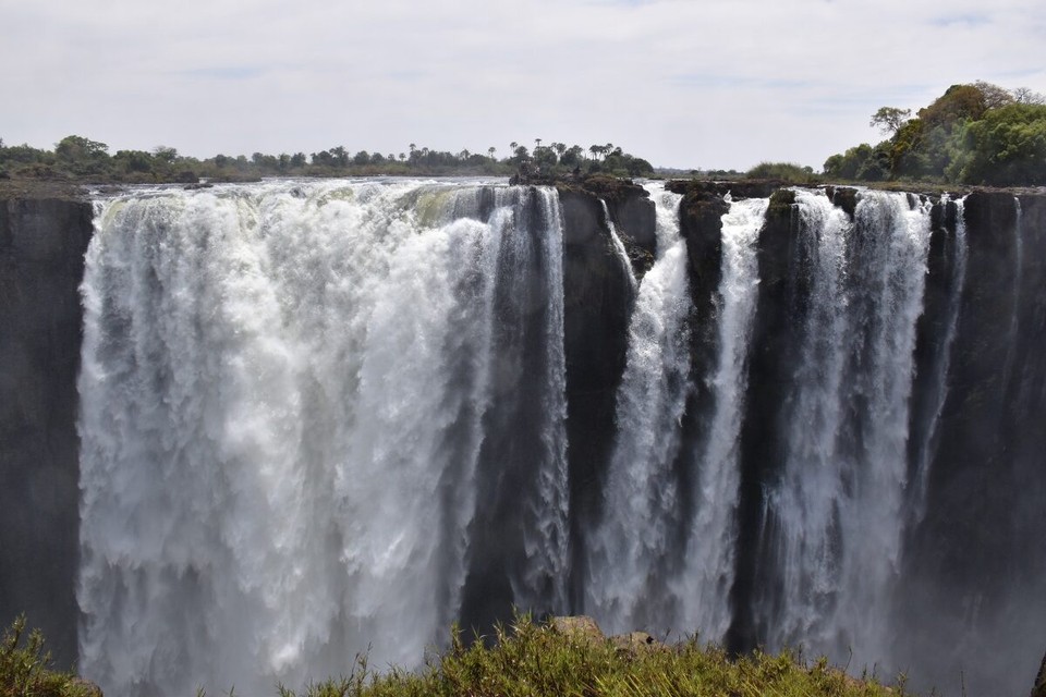 Simbabwe -  - Der Devil's Pool bei den Viktoriafällen, in der Mitte des Bildes, ist ein natürlicher Infinity-Pool am Rand des Wasserfalls, der nur während der Trockenzeit zugänglich ist.