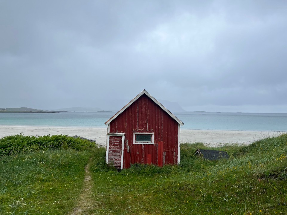 Norwegen - Ramberg - Ein typisches rotes Fischerhäuschen am Strand 