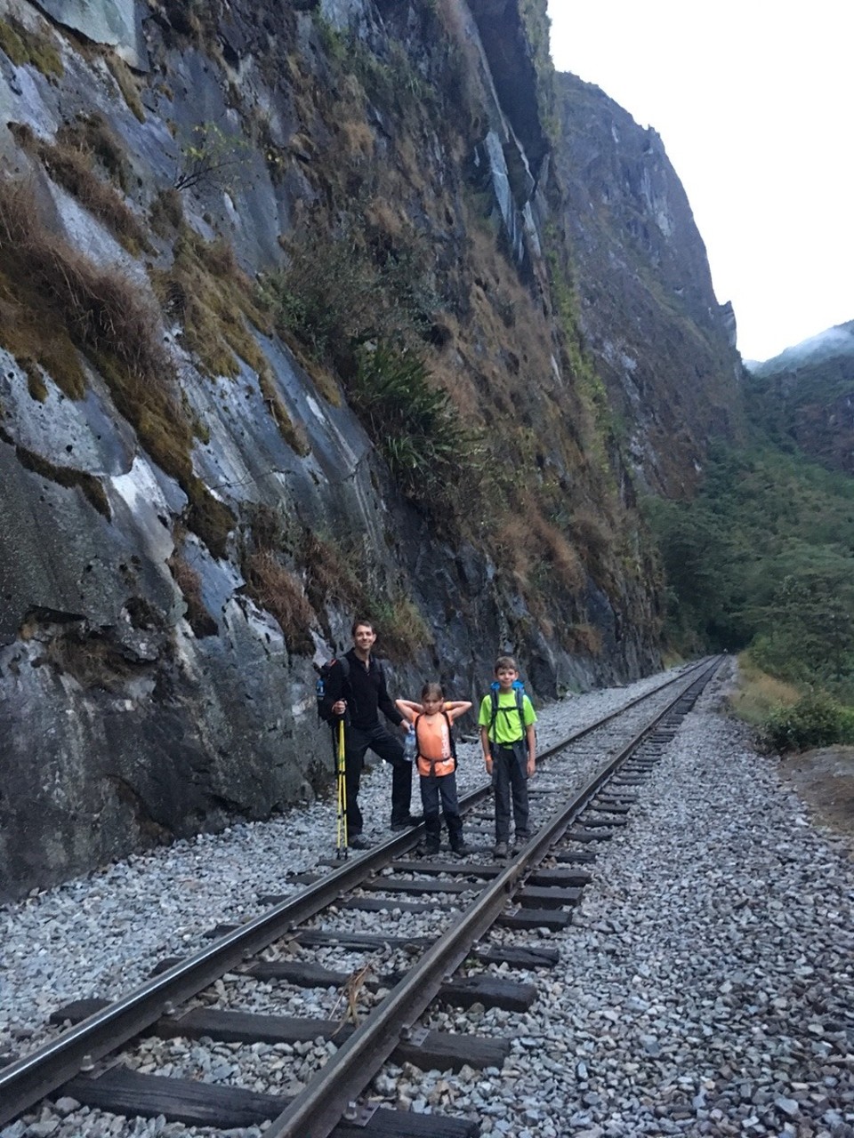 Peru -  - Teil 2
Um 5:00 Uhr morgens machten wir uns nach einer holperigen Bus-Fahrt auf nach Agua Calientes. Wir sind übermüdet und durstig. Nach 22h Busfahrt haben wir nur noch wenig Trinkwasser. Der Fahrer zeigt uns in welche Richtung wir jetzt die 12 Kilometer nach AC laufen sollten. Auf dem Weg gäbe es Shops um uns einzudecken. Leider waren diese in den frühen Morgenstunden allesamt geschlossen. In einem Restaurant entdecke ich eine Frau, die soeben dabei ist, den Boden aufzunehmen. Glücklicherweise verkauft sie uns 5 Liter Wasser. 
Nach 2.5h wandern erreichen wir AC bei Tagesanbruch. Sofort begeben wir uns zum Platz wo uns ein Guide die Tickets nach Machu Picchu überreichen sollte. Dieser ist allerdings nicht auffindbar. Ich rufe die Agentur an welche mir ein baldiges eintreffen garantiert. Tatsächlich werden wir bereits nach 2 Minuten vom Guide gesucht. Der Guide hat allerdings keine Tickets dabei. Auf den Hinweis, dass wir uns beeilen müssten für den MP Besuch teilt uns dieser mit, dass wir keine Vormittags-, sondern Nachmittag-Tickets hätten. Wir begannen zu Rechnen und stellten fest, dass die vereinbarte Tour und Rückreise so gar nicht möglich war... 