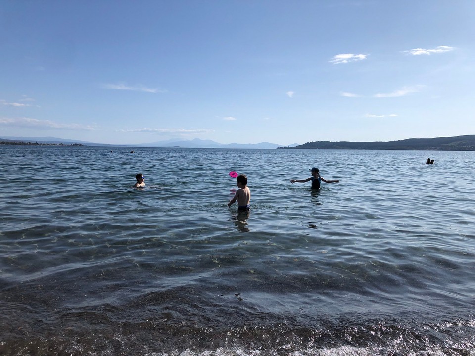 Neuseeland - Taupo - In Taupō geniessen wir einen Nachmittag am herrlichen Strand. Das Wasser ist wärmer als erwartet. Im Hintergrund sind Tongariro und Kollegen von der anderen Seite. 