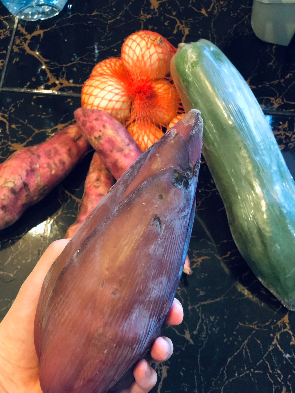 Thailand - Chiang Mai - In unserem Muban wird regelmäßig Gemüse verkauft. Ich habe mal Bananenblüte probiert…überzeugt mich jedoch nicht. 
Im Hintergrund liegen grüne Papaya, Süßkartoffeln und Zwiebeln. 