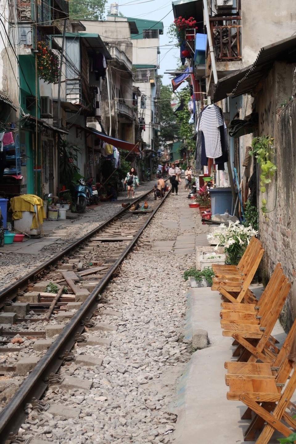 Vietnam - Hanoi - Mitten in der Altstadt befindet sich eine schmale, scheinbar namenlose Gasse, die so eng ist, dass selbst ein Auto kaum hindurch käme. Doch statt einer Straße oder einem Gehweg ist in der engen Häuserschlucht gerade mal Platz für ein Bahngleis. Die Menschen, die links und rechts davon leben, gehen wie alle anderen auch, ihren täglichen Geschäften vor der Haustür nach. 

