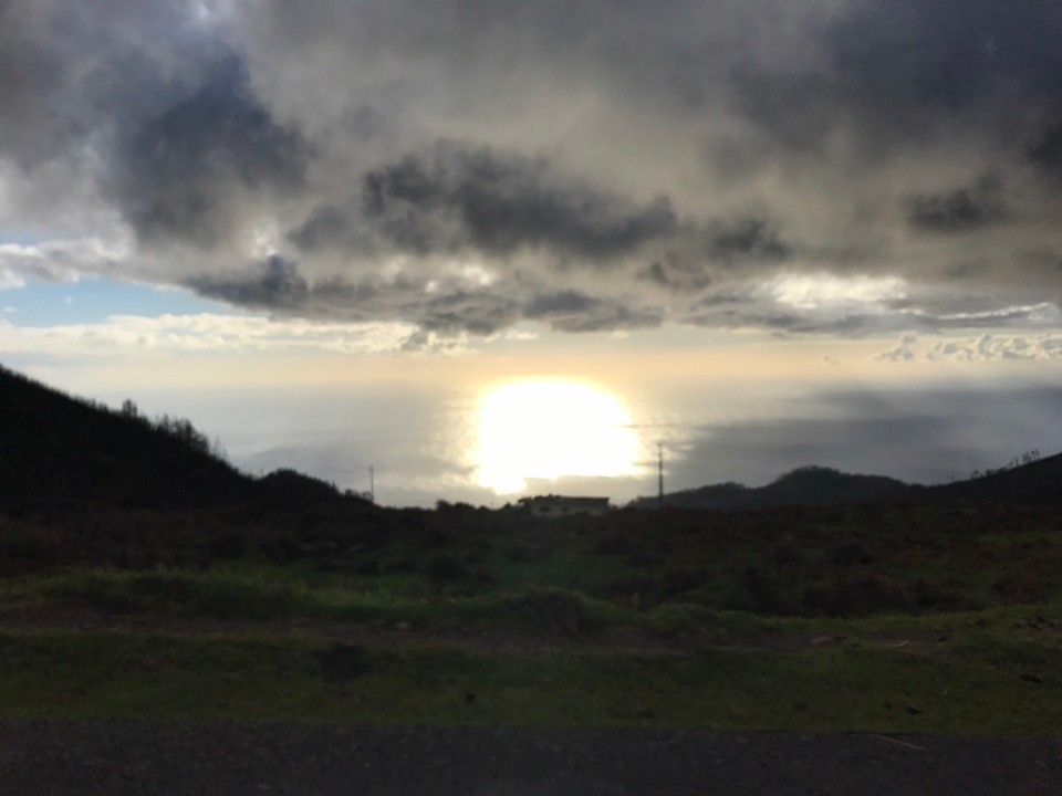 Portugal - Porto Moniz - Die Sonne scheint von unten!? Versteckt  hinter Wolken - ur das reflektierende Licht auf der Wasseroberfläche erhellt die Umgebung.