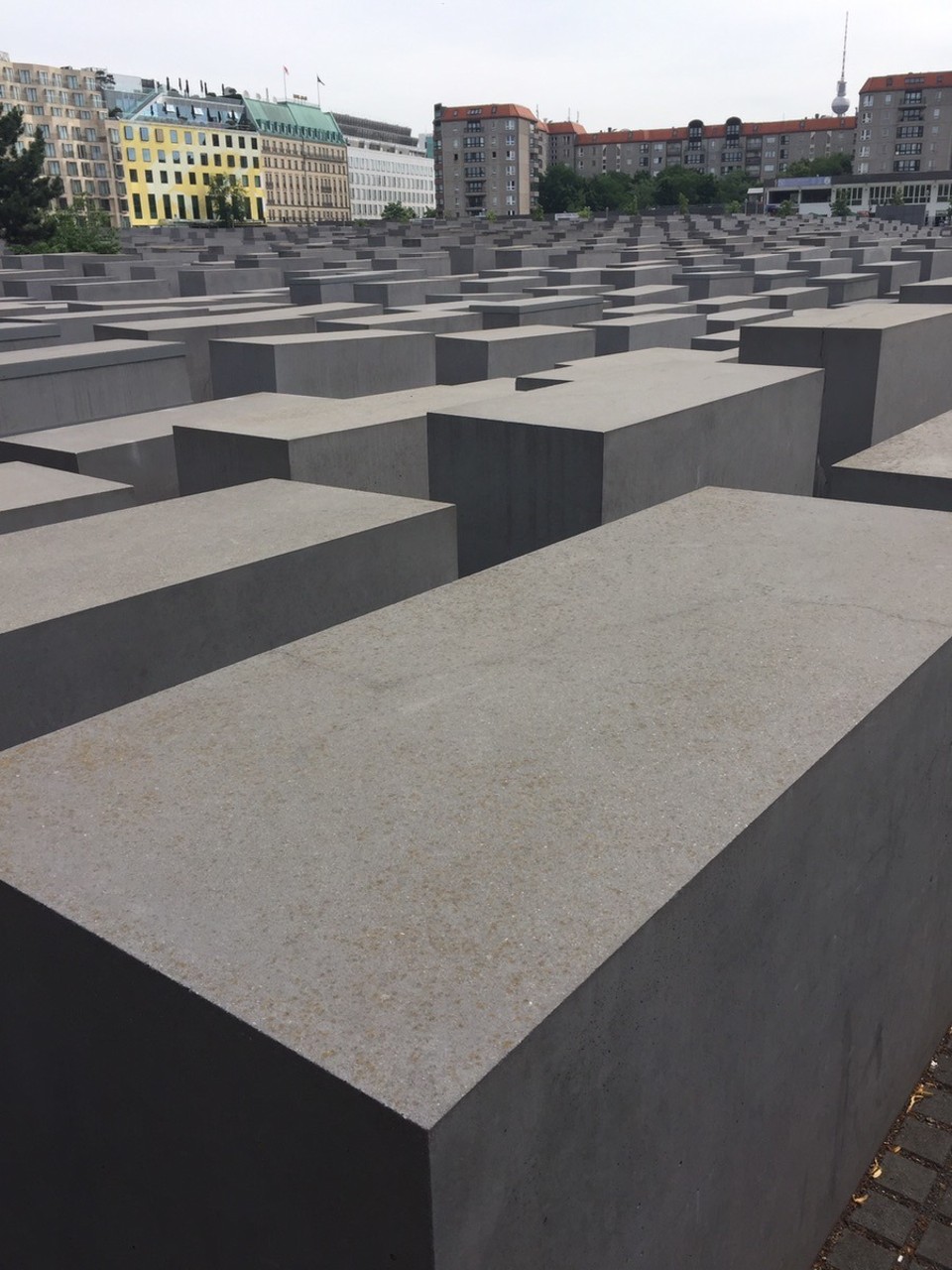 Germany - Berlin - After day 1 of the conference Mandy and I enjoyed a drink at the back of the Ritz-Carlton and then had a bite to eat near the gate. 
To get to the gate from Potsdamer Platz you pass the Memorial to the Murdered Jews of Europe.

The memorial, also known as the Holocaust Memorial is a memorial in Berlin to the Jewish victims of the Holocaust. It consists of a 19,000 m2 (4.7-acre) [2][3] site covered with 2,711 concrete slabs or "stelae", arranged in a grid pattern on a sloping field. 
According to the architect's project text, the stelae are designed to produce an uneasy, confusing atmosphere, and the whole sculpture aims to represent a supposedly ordered system that has lost touch with human reason.



