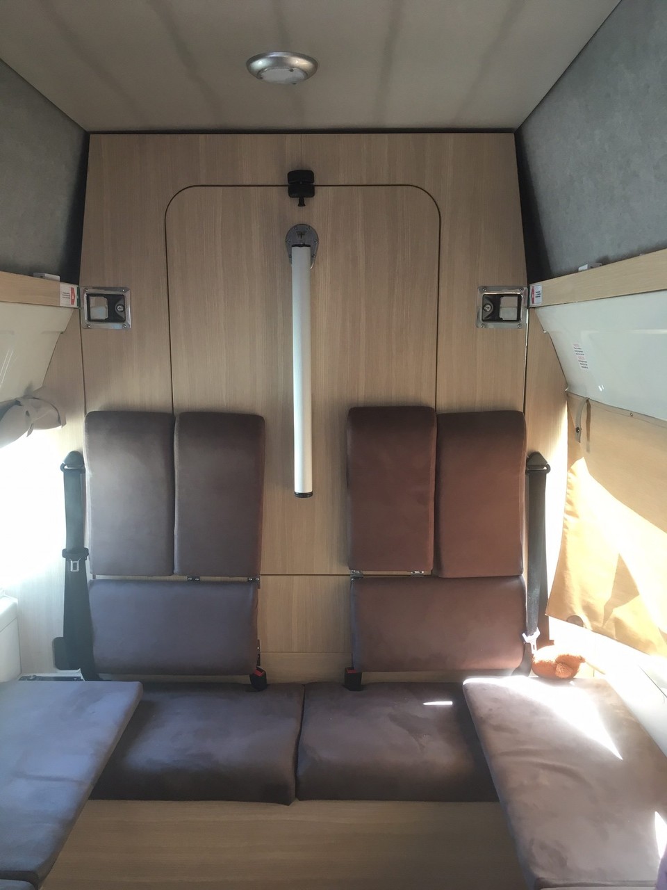 Neuseeland - Harewood - Auf der Rückbank haben zwei Personen Platz zum Sitzen. Darin integriert ist einerseits der Esstisch und andererseits das untere Bett. Unter den Bänken gibt es zwei grosse Fächer für die Kinderrucksäcke und unsere Kleiderpäcklein.