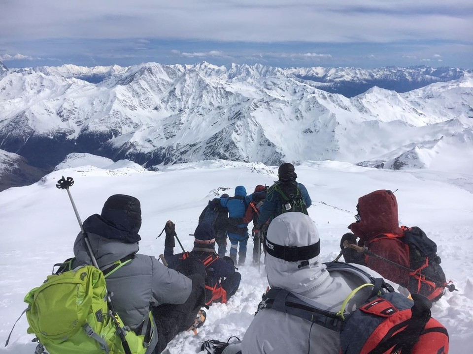 Russland - Terskol - Dieses Bild kann nur ansatzweise unsere Erschöpfung zeigen und welch langer Weg es noch bis zu unserer Hütte war. Wir waren am Ende unserer Kräfte. Vorne sieht man Nikita, der von Anton und Alex gestützt wird. Er kann sein Körper aus eigener Kraft nicht mehr auf den Beinen halten. Alle 50 m machen wir eine Pause. Jeder Einzelne ist froh und dankbar für jeden kurzen Halt. Jeder kniet sich oder setzt sich hin. Kurz vor und auf dem Gipfel hatte ich einen Hype und mein Adrenalin hat mich auf den Gipfel getragen. Nikita und ich hielten uns mit Tränen in den Augen in den Armen. Ich betete zu Gott, dass er uns sicher nach unten bringt. Mit Beginn des Abstieges bekam ich ganz schwer Luft und musste ganz tief und intensiv atmen. Es waren nur kleine, wenige Schritte und musste nach Luft holen, als wäre ich gerade einen Triathlon gelaufen. Bei den kurzen Pausen schlafe ich aus Erschöpfung immer wieder ein und wache schlagartig und erschrocken wieder auf, reiße die Augen weit auf und schnappe ganz tief nach Luft. 3 Stunden Abstieg lagen noch vor uns. Erst im Camp konnte ich langsam wieder normal atmen. - Laubi 