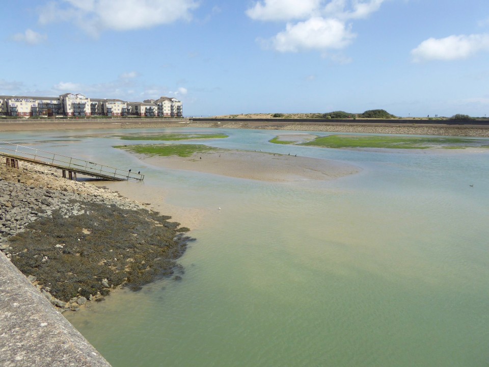 United Kingdom - Eastbourne - Flooded gravel pits and ponds on the Crumbles were filled-in or adapted to create the harbour arms in 1993. The Outer Harbour needs frequent dredging to keep the channel from the sea open and deep enough, and shingle that used to move by longshore drift now has to bypass the harbour using lorries.