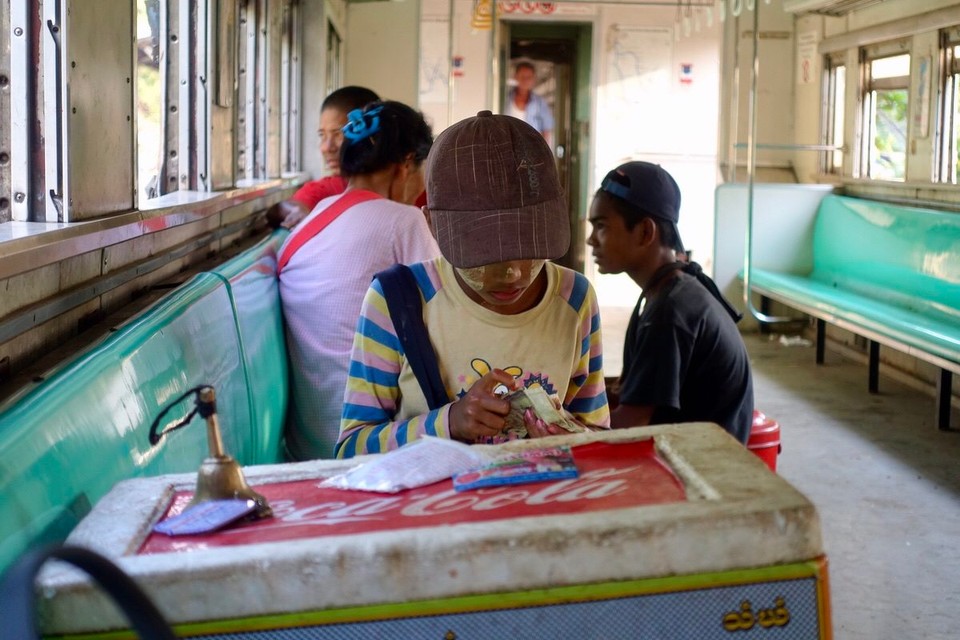 Myanmar (Burma) - Yangon - Lokal gutt som selger saftis til 100kyat stykke (60 øre) teller pengene sine. 