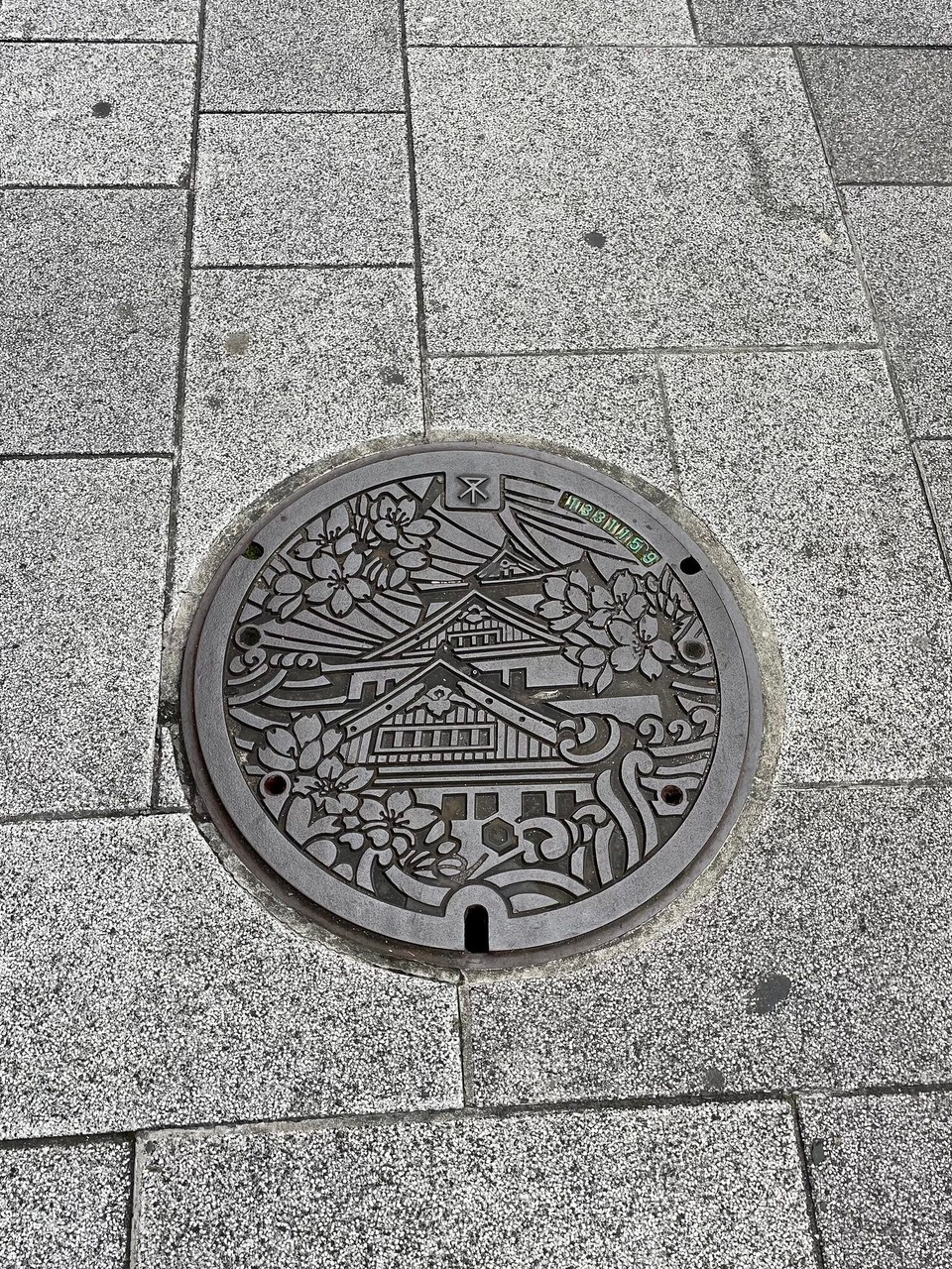 Japan - Osaka - D Schachtdeckel sind in Japan alli mit Wohrzeiche verseh