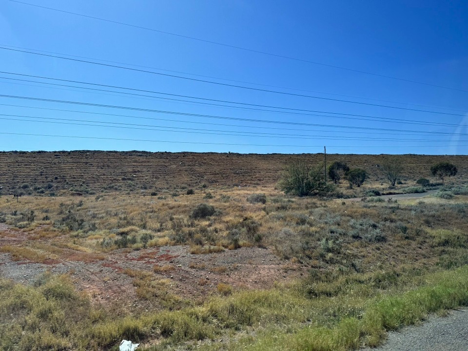 Australien - Trafalgar - De künstlich Damm hens weg dr Staubentwicklig und am Lärm boua, will d Mina rächt noch ar Stadt Kalgoorlie-Boulder isch. Dr Guide beschribt dr Damm so: Het a hufa kostet, nützt nüt geg da Staub, gsiat abr no guat us.