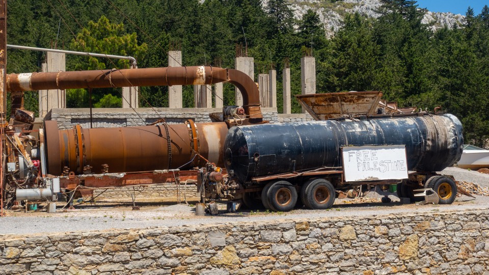 Griechenland - Symi - Ggü. Dem Notahlt befindet sich Schrott, sollen wir die Elektrokarre gleich dazuschieben? Das Banner richtet sich an die Weltöffentlichkeit. Nur befindet die sich nicht hier.