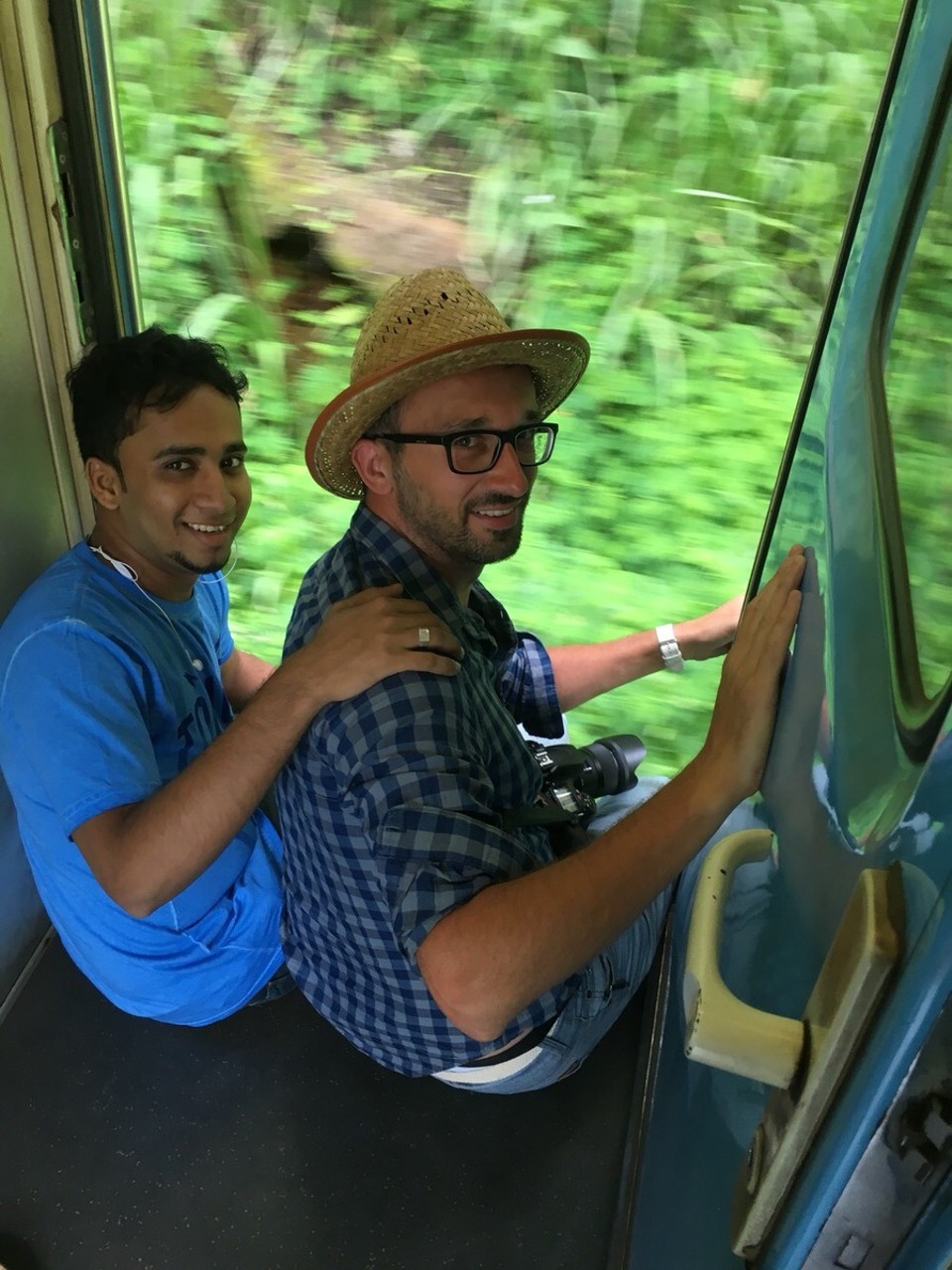 Sri Lanka - Kandy - Im Reiseführer laß ich, dass die Türen der Wagons offen sind und das das der beste Platz für die Fahrt sei. Also nichts wie hin!
Dort treffe ich Fahil, mit dem ich mich anfreunde und die meiste Zeit abhänge. Er zeigt mir wie ich mich sicher aus dem Zug hängen, richtig am Rand sitze und wann ich die Füße lieber einziehen sollte. Mit einem Joghurt, den er mir spendiert, besiegeln wir unsere Freundschaft. :D