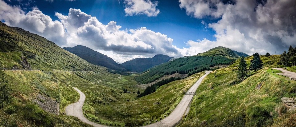 United Kingdom - Arrochar - Am Gipfel weht der Wind so heftig, dass ich kaum stehen kann. Die letzte Abfahrt durch die faszinierende schottische Hügellandschaft steht bevor. Beim Check des Höhenprofils und der Route. wird mir bewusst, dass ich nach dem Loch Lomond die Szenerie der letzten zehn Tage endgültig hinter mir lassen werde. 
Interessant, dass, im Spiegel des nahenden Abschluss’ dieser fordernden Etappen im schottischen Hochland, zaghaft Wehmut in den Gefühlshaushalt eintropft.
Ich habe eine Woche geflucht, geschwitzt, gestrampelt und gejammert. Jetzt, beim Anblick dieser einzigartigen Kulisse und des nahenden Abschieds, wird mir schlagartig bewusst, ich habe es geliebt.