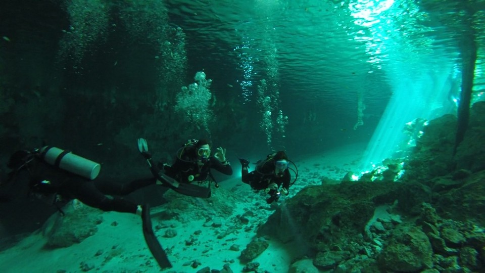 Mexiko - Dos Ojos Cenote - Die Sonnenstrahlen, die das klare Wasser brechen, versetzen einen in eine andere Welt... Hier sieht man Stephan und Kathi in Tauchausrüstung.