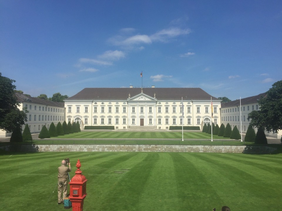Germany - Berlin - Schloss Bellevue. 
The Bellevue Palace is a white palatial home of the German president with 3 wings built in 1786. I don't stop but the bus does, allowing a perfect opportunity to grab this photo.
