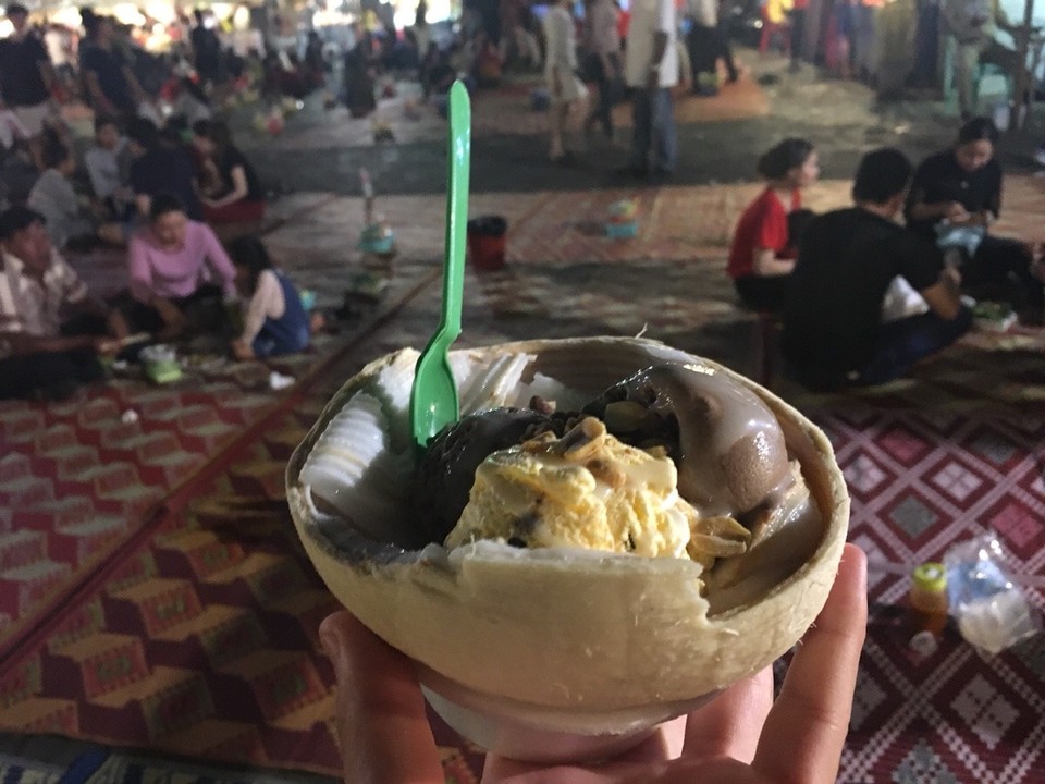 Cambodia - Phnom Penh - Eiscreme auf frischen Kokusnussstreifen in einer Kokusnuss. Natürlich traditionell mit den anderen Khmer auf dem Boden gegessen.