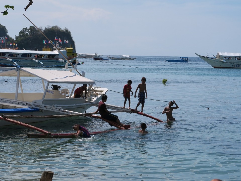 Philippines - Puerto Galera - Plage de Sabang : les enfants jouent sur la banka