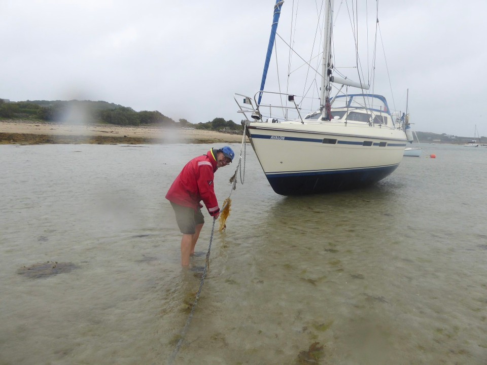United Kingdom - Isles Of Scilly - Inspecting the anchor and chain.