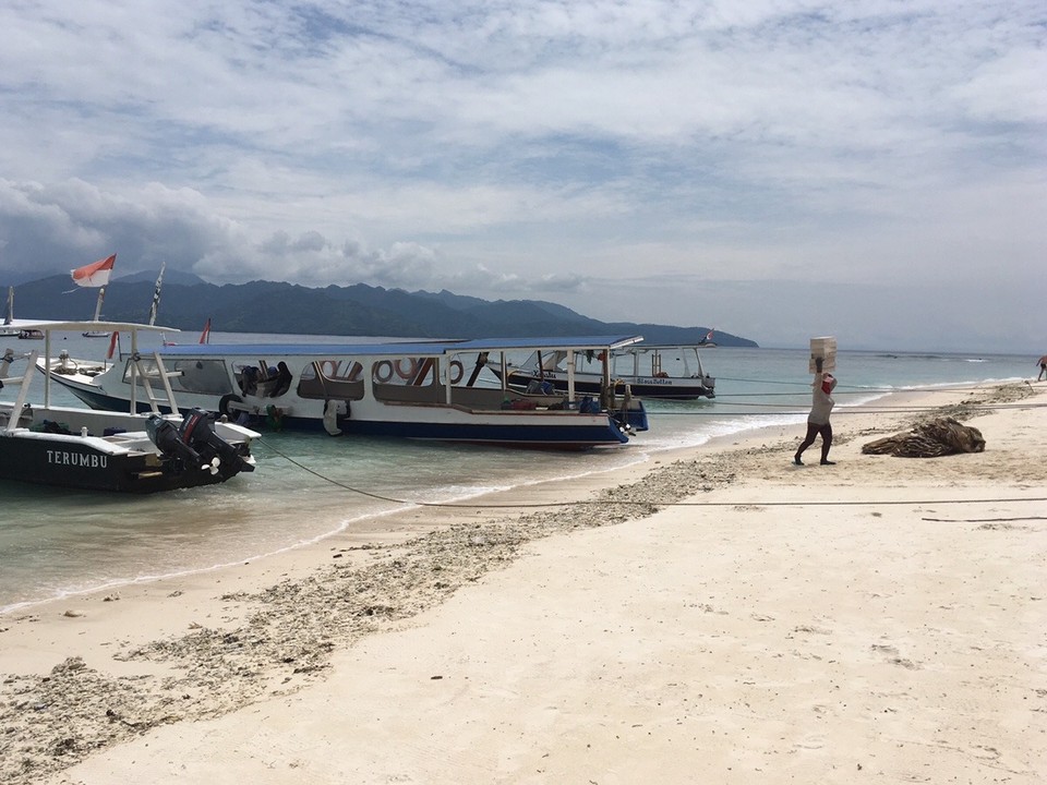 Indonesien - Lombok Utara - Alle Waren für die Insel werden per Boot gebracht - hier Steine für einen Bau, die von Frauen (!!!) auf dem Kopf vom Boot getragen werden