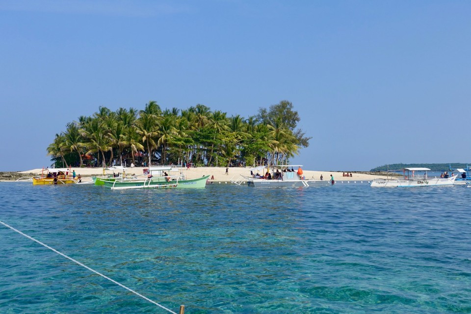 Philippines - Siargao Island - Guyam island. En hvit strand, palmer og noen hengekøyer. 