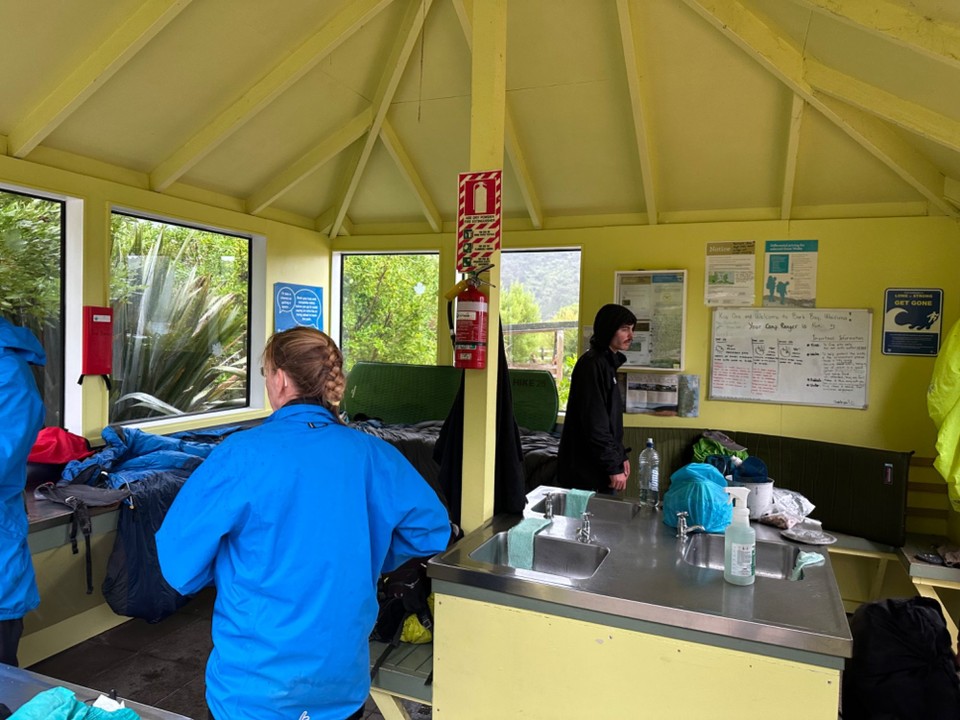 Neuseeland - Abel Tasman National Park - Da es erst mal einen richtigen Platzregen hatte, haben wir im offenen Küchenshelter einem Pärchen geholfen, ihre Schlafsäcke auszuringen, die sind heute Nacht in ihrem undichten Zelt etwas nass geworden. 🙈