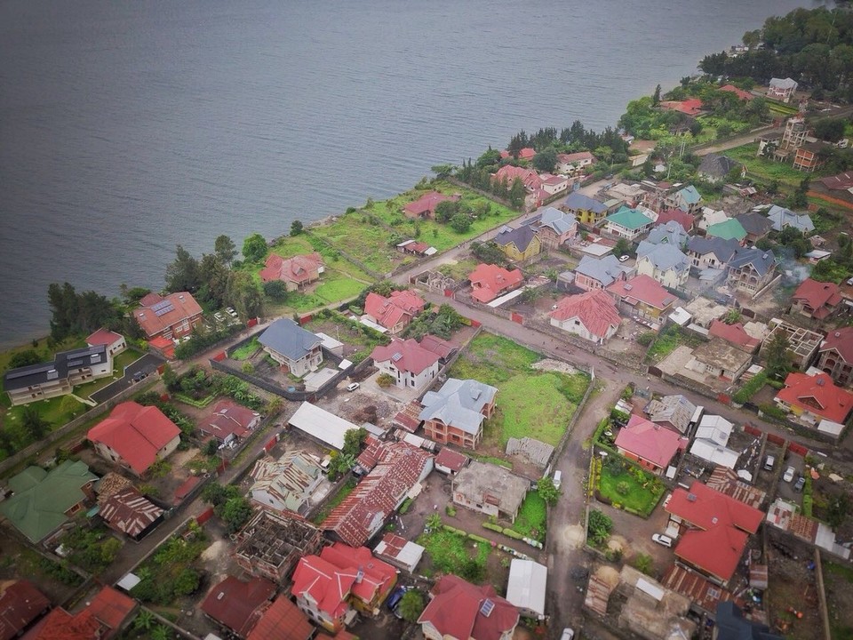 Demokratische Republik Kongo - Goma - Um einen besseren Überblick über das Grundstück zu erhalten, hat Nikita Bilder mit der Drohne geschossen. Die Lage in zweiter Reihe zum See ist super, Strom- und Wasserversorgung wären gegeben und es liegt in einer vergleichsweise sicheren Gegend.
Der Eigentümer war von der Drohne sehr angetan und hat sich sehr interessiert. Das Angebot, eine Drohne abkaufen zu können, war bisher allerdings kein Argument für ihn, uns den Zuschlag für das Grundstück zu geben.