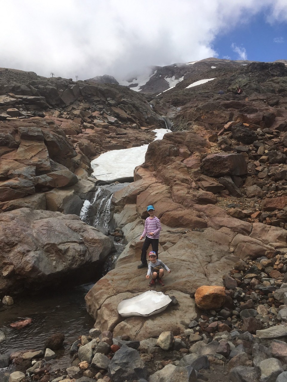 Neuseeland -  - Der Weg ist ziemlich steinig und geht vorbei an Schneefeldern und Wasserfällen.