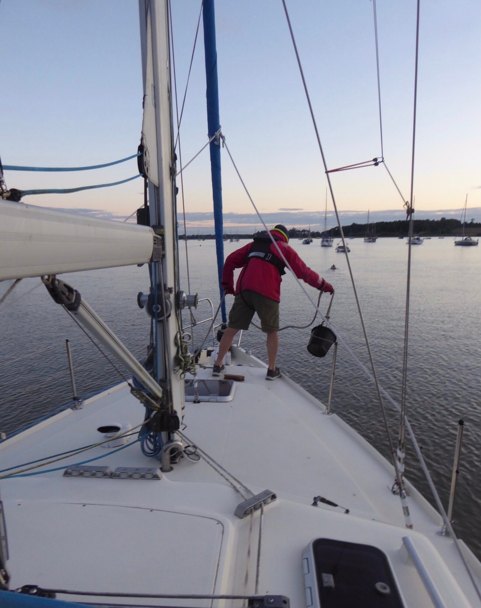 United Kingdom - Southwold - Cleaning the deck of East Coast mud and weed after leaving our mooring buoy.