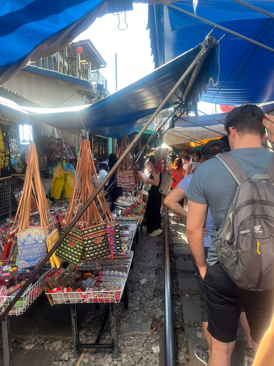 Thailand - Bangkok - When the trains pass, the covers have to go up and everyone must stand behind the red line. It becomes a free for all to take your pictures and videos 😂