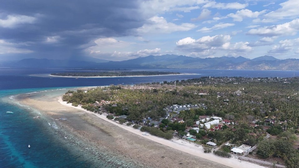 Indonesien - Kabupaten Lombok Utara - Im Vordergrund üsi "Partyinsla" Gili Trawangan. Ir Mitti dia beida Insla Gili Meno und derhinder Gili Air und gross im Hintergrund Lombok.
