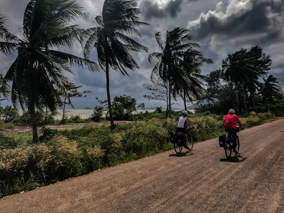Thailand - Amphoe Thung Tako - Starker Wind vom Meer treibt dunkle Regenwolken vor uns her. Immer wieder scheint es, als würde jeden Moment ein Regenguss über uns hereinbrechen.
Doch wenn Engel reisen...